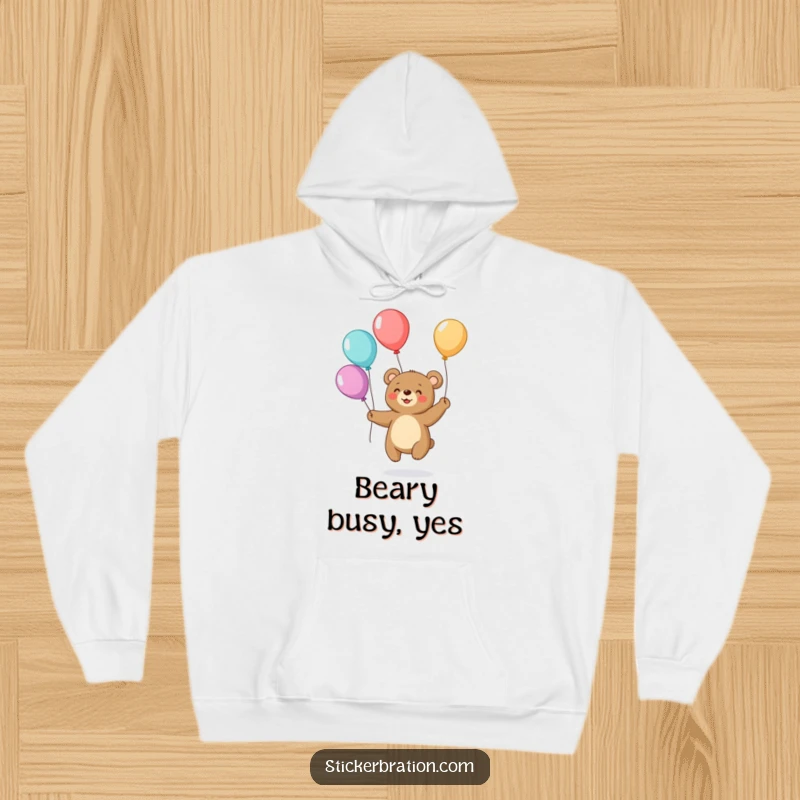 Funny hoodie showcasing a small, smiling bear effortlessly juggling colorful balloons, creating a warm and humorous appeal.