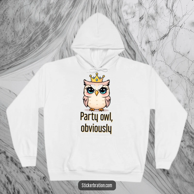 Funny hoodie illustrating a startled owl with large eyes wearing a tiny, colorful party crown, symbolizing surprised joy.