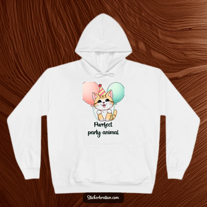 Funny hoodie with a happy cat wearing a party hat, peeking from behind balloons, offering cozy comfort and festive vibes.
